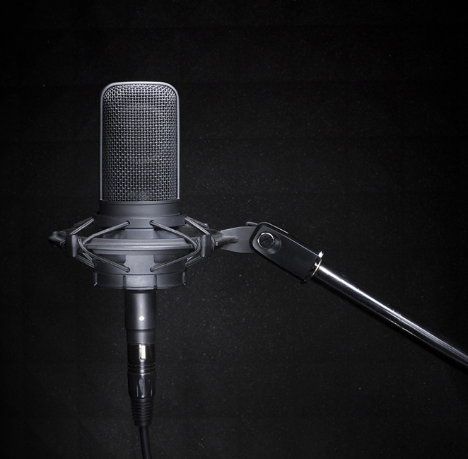 Professional studio recording microphone on the dark, black background with copy space for broadcast or recording studio banner